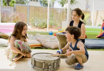 three kids having fun with drums